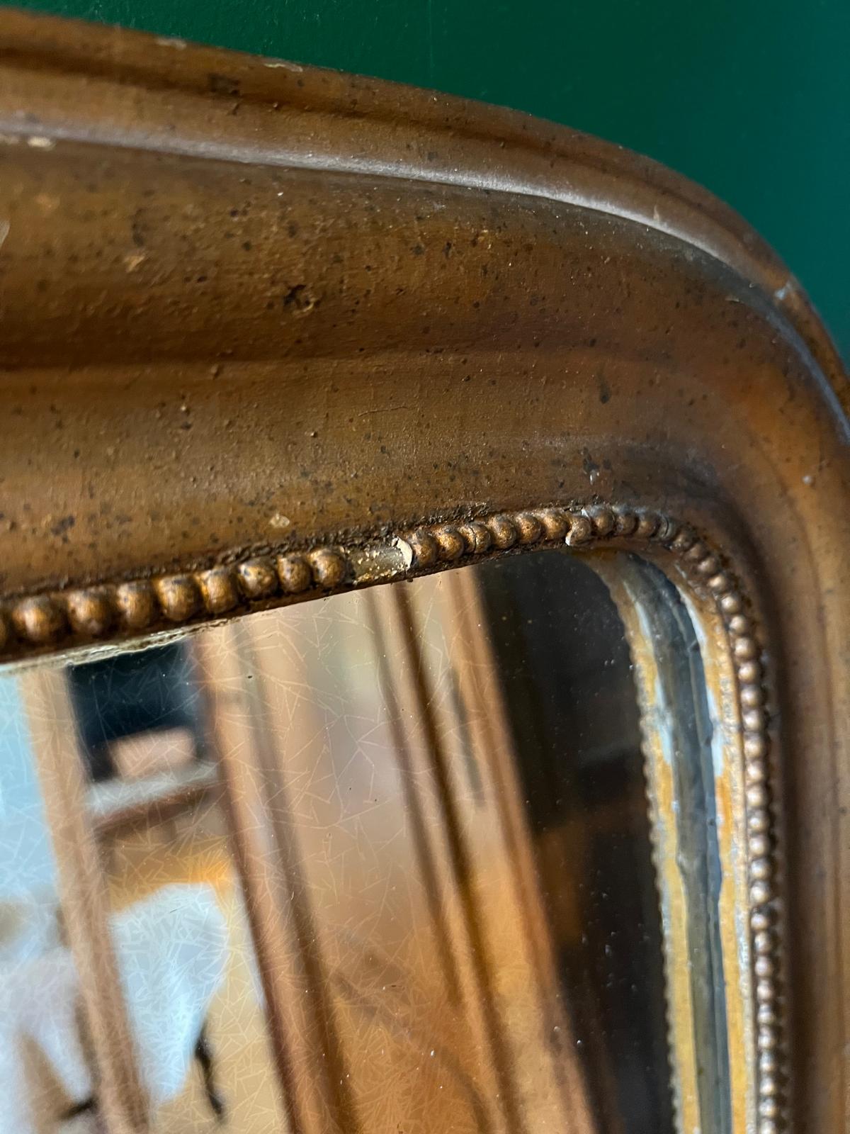 Close-up of La Ferme Anglaise antique French Louis Philippe gilt mirror showing beaded border and foxed glass