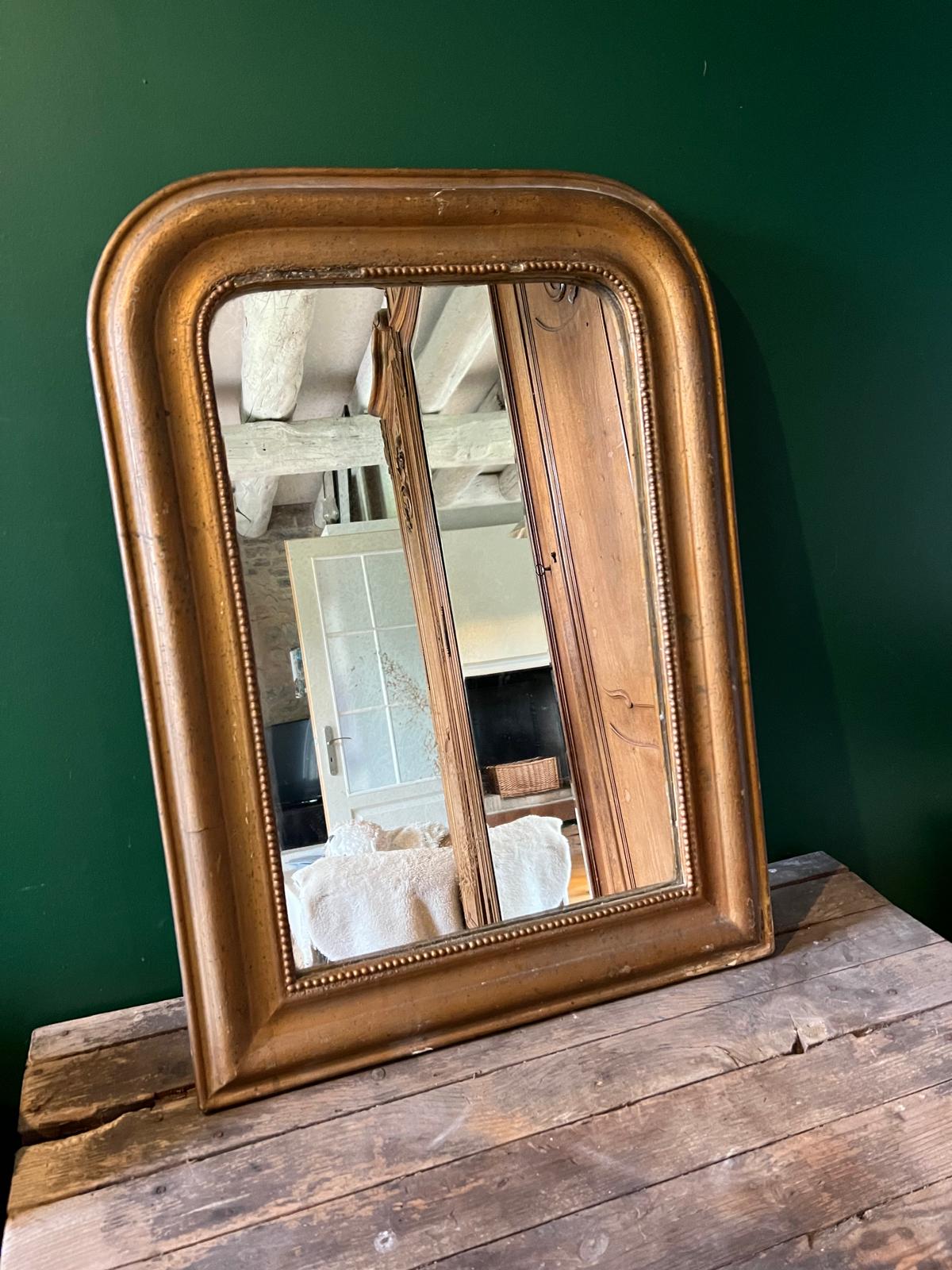 La Ferme Anglaise antique French Louis Philippe gilt mirror with a warm bronze-gold frame and decorative beaded border.