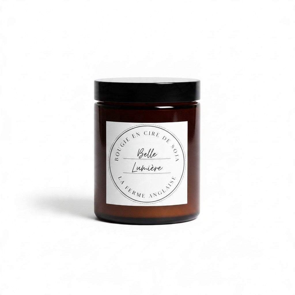 La Ferme Anglaise Belle Lumière soy wax candle in an amber glass jar with a black screw-top lid on a white background.