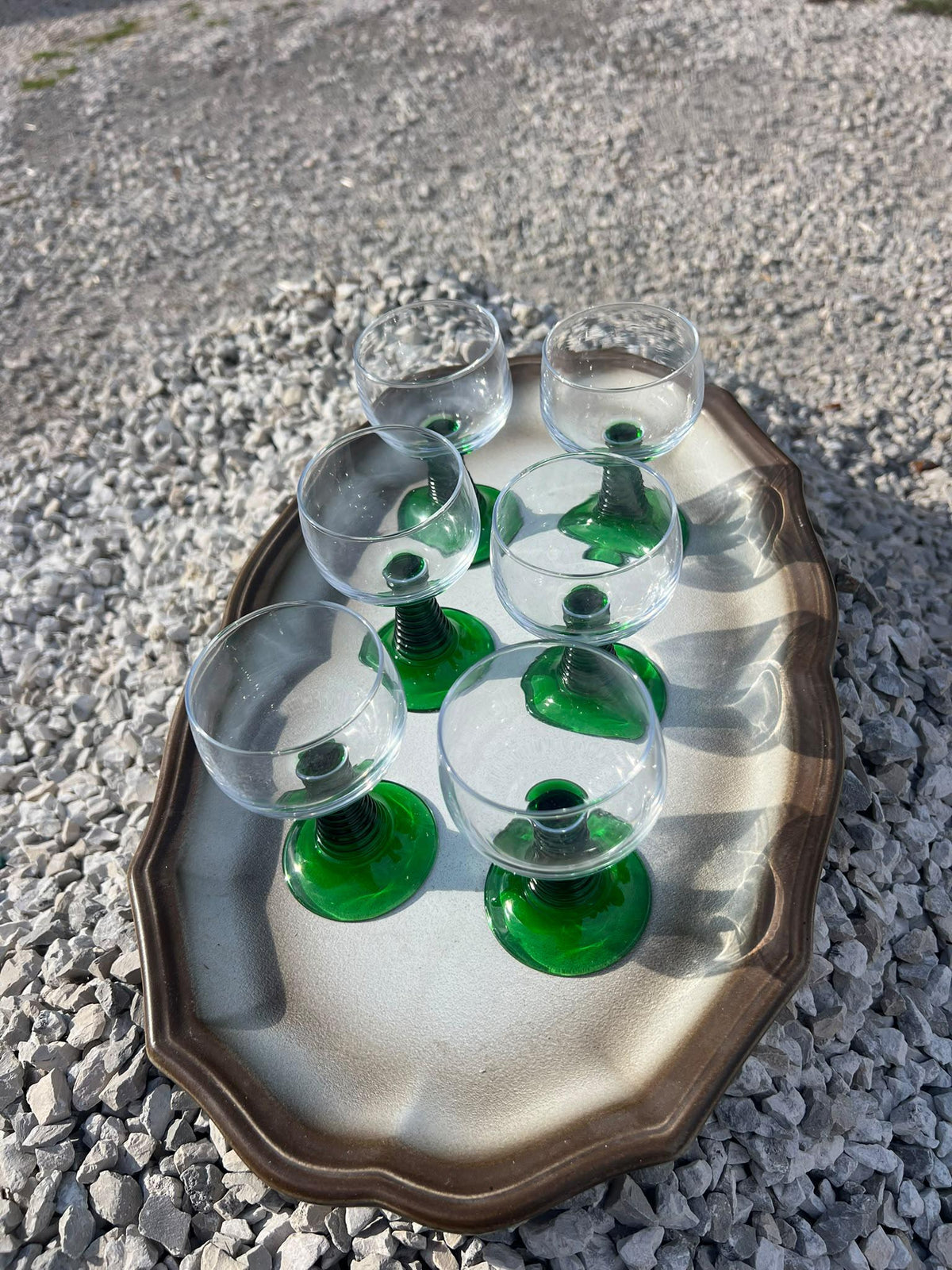 La Ferme Anglaise set of six vintage French bistro wine glasses with clear bowls and vibrant green stems on a tray.